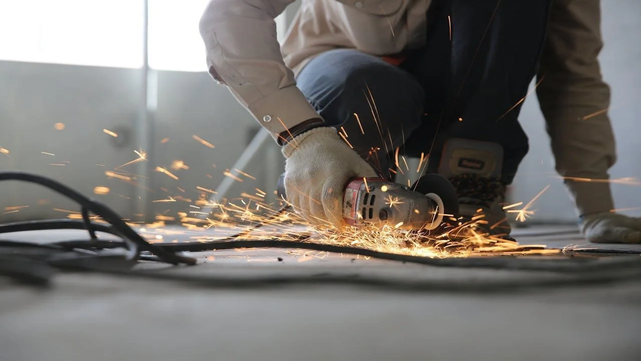 A person holding a grinder while making sparks